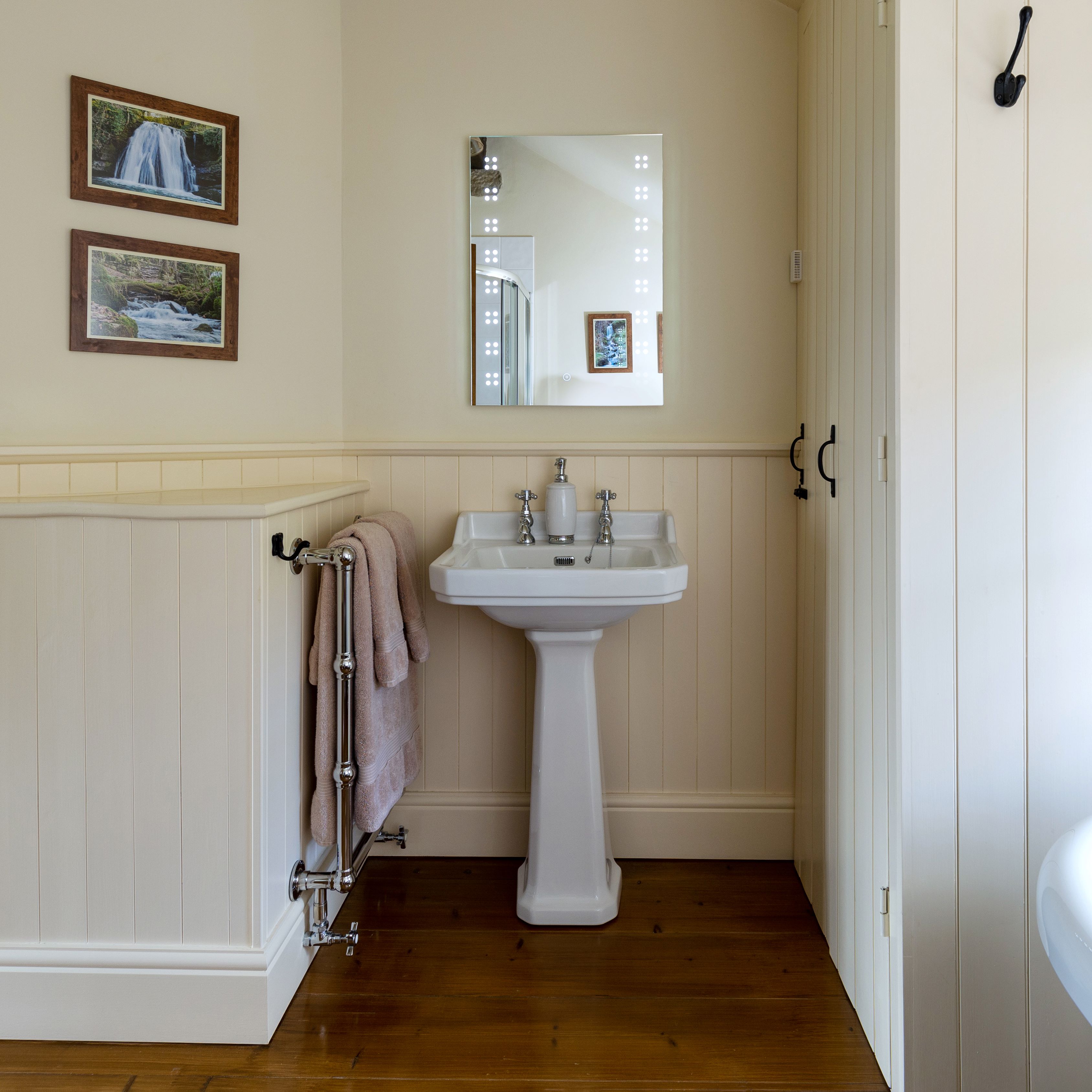 Traditional style white pedastal sink with mirror above