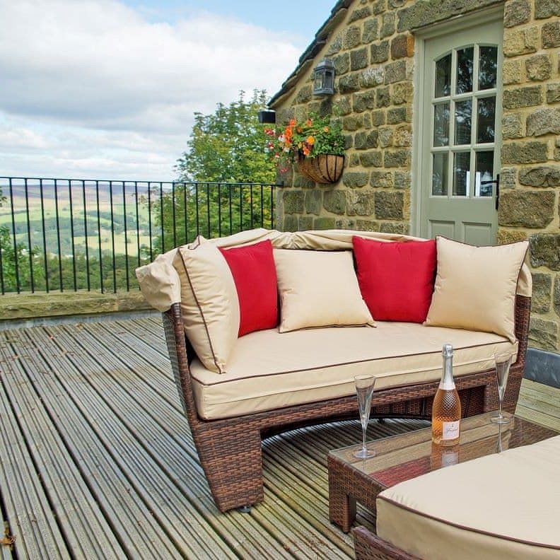 Outdoor sofa on a raised terrace with a view of rolling hills in the background